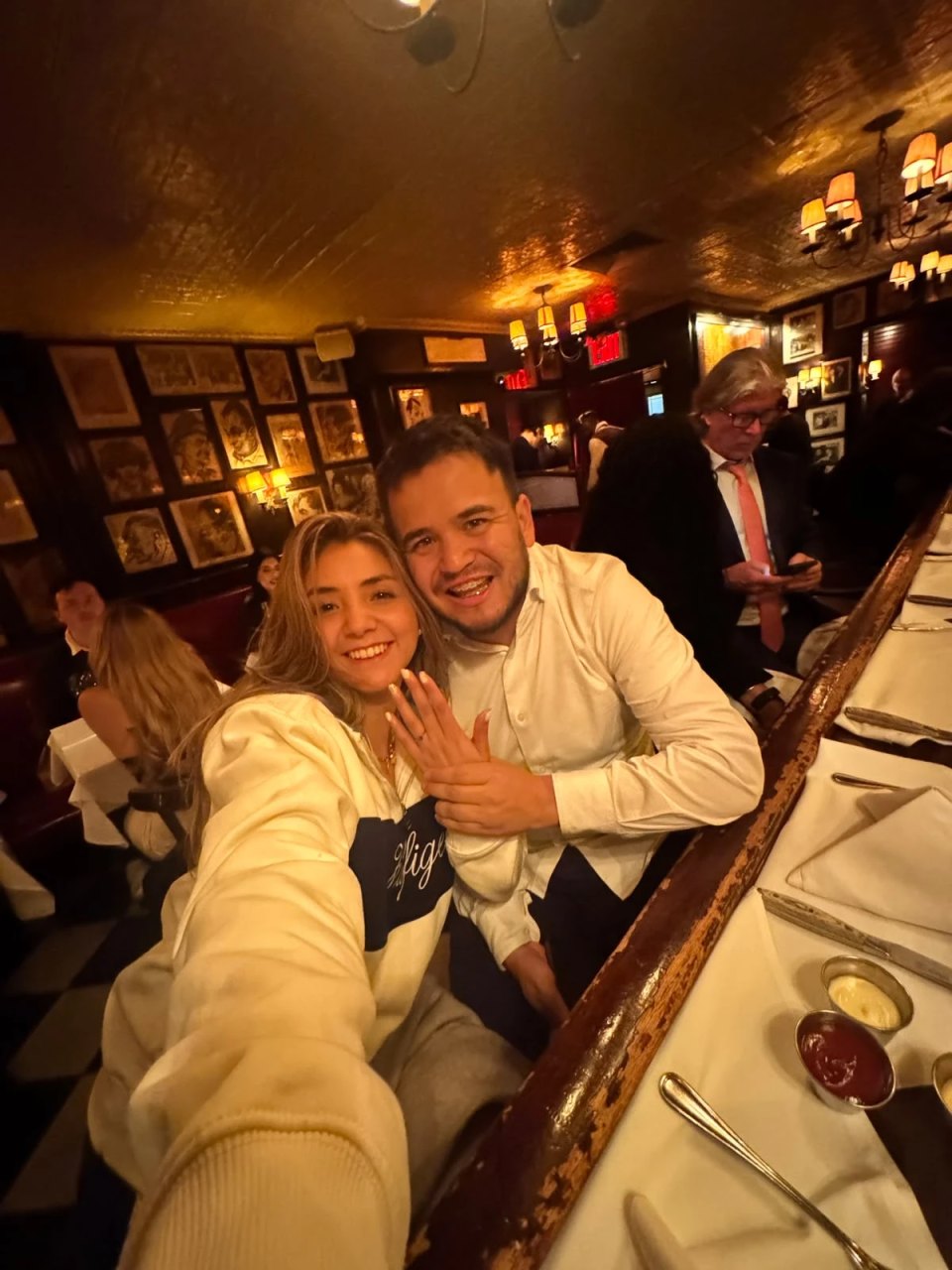 Danny y Luisa mostrando el anillo de compromiso en un restaurante de Nueva York